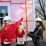group of three help at a Habitat for Humanity home construction site
