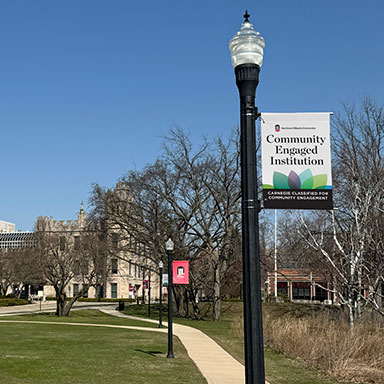 light post banner mockup with "Community Engaged Institution" and logo