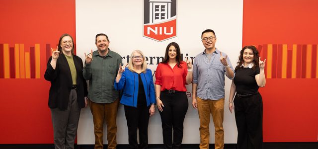 Melissa Fickling, TJ Schoonover, Suzanne Degges-White, Dana lsawi, Peitao Zhu, and Yenitza Guzman pose with Huskie hand gentures.