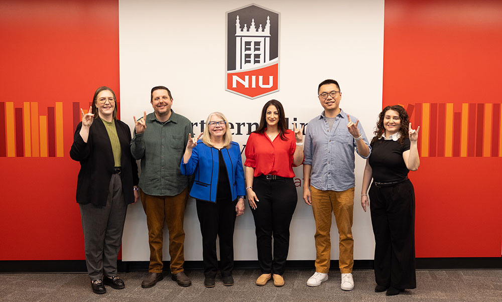 Melissa Fickling, TJ Schoonover, Suzanne Degges-White, Dana lsawi, Peitao Zhu, and Yenitza Guzman pose with Huskie hand gentures.